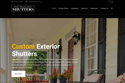 Web Design & Development 11 A front porch with black shutters, a white door, and chairs with striped cushions.