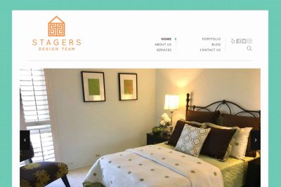San Carlos Website Design 8 A neatly staged bedroom with a made bed, two framed art pieces, and a bedside lamp.