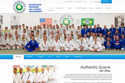 Los Altos Web Design 5 Large group of people in jiu-jitsu uniforms posing in front of academy banners on a mat.